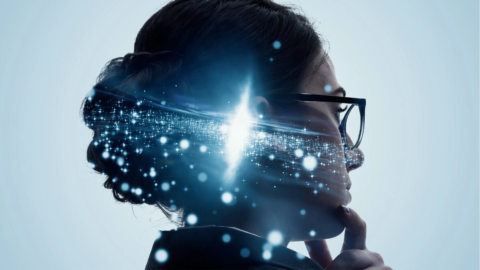 Profile of a person wearing glasses with glowing light particles